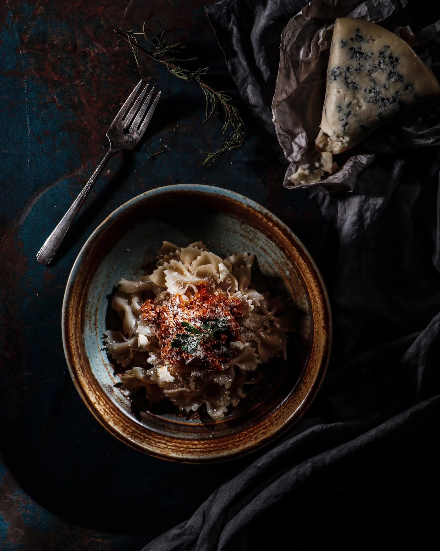 Handmade pasta with tomato and grated cheese in a rustic bowl, seen from above